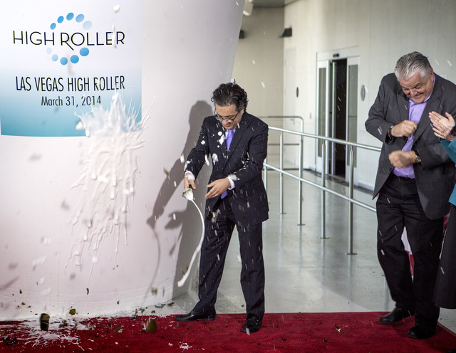 Tariq Shaukat, Caesars Entertainment chief marketing officer, left, christens the High Roller at The Linq with a bottle of champagne as Clark County commissioner Steve Sisolak, right, reacts on Mo ...