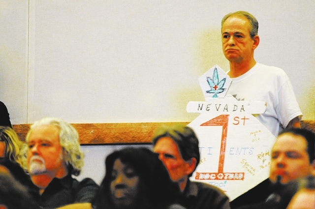 William Baker, member of marijuana patient advocate group WECAN, holds a sign in support on a new ordinance that would allow dispensaries for medical marijuana in Clark County during an open forum ...