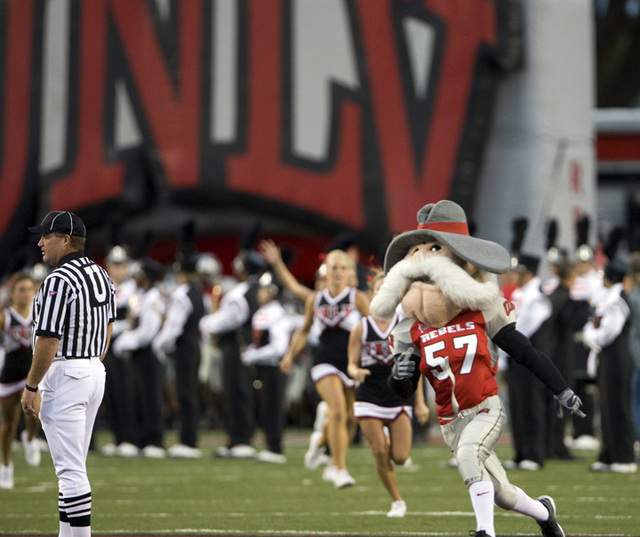The "Hey Reb" mascot, followed by cheerleaders, run onto the field before UNLV takes on Utah St ...