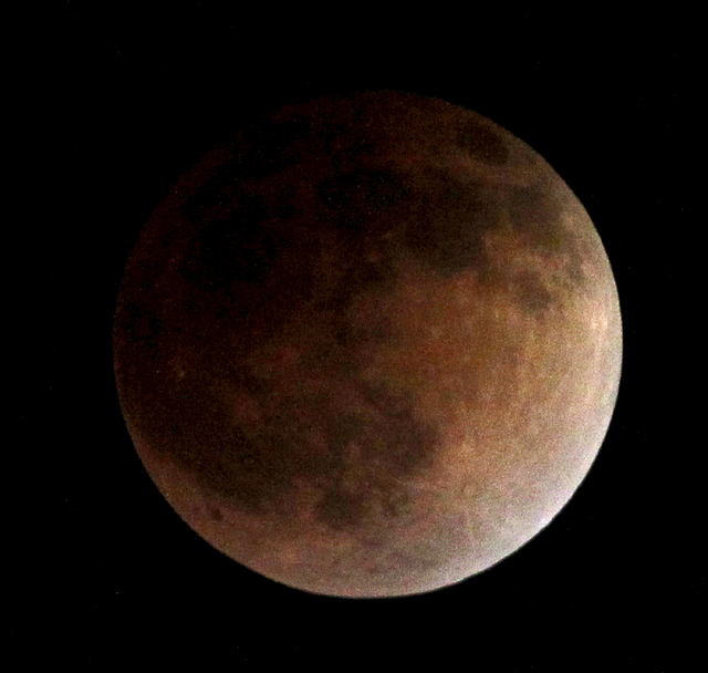 As the moon completely crosses the earth's shadow, the first of four total lunar eclipses this year and next, called the "blood moon," occur in Whittier, Calif., on Tuesday, April 15, 2014. (AP Ph ...