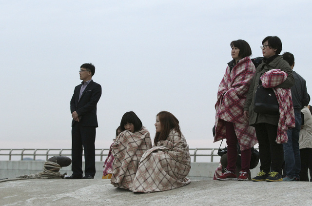 Relatives wait for their missing loved ones at a port in Jindo, South Korea, Wednesday, April 16, 2014. A ferry carrying 459 people, mostly high school students on an overnight trip to a tourist i ...