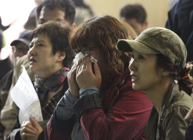 A mother weeps as she and others search for their children's names among a list of survivors rescued from a ferry that sank off the country's southern coast, at Danwon high school in Ansan, South  ...