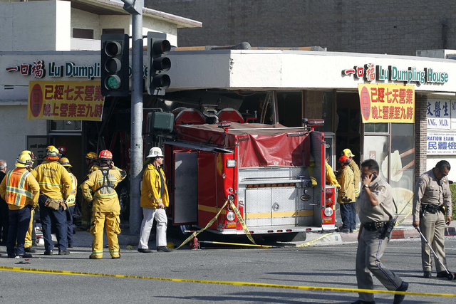 Firefighters and other officials work the scene of an accident where two firetrucks answering a call collided en route to a fire Wednesday, April 16, 2014, in Monterrey Park, Calif. The collision  ...