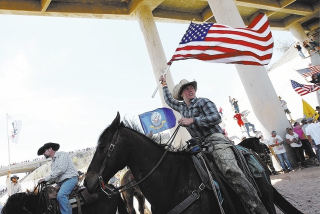 Arden Bundy, son of rancher Cliven Bundy, flies the American flag under the I-15 highway near Bunkerville after the BLM agreed to release his family's cattle on April 12, 2014. (Jason Bean/Las Veg ...
