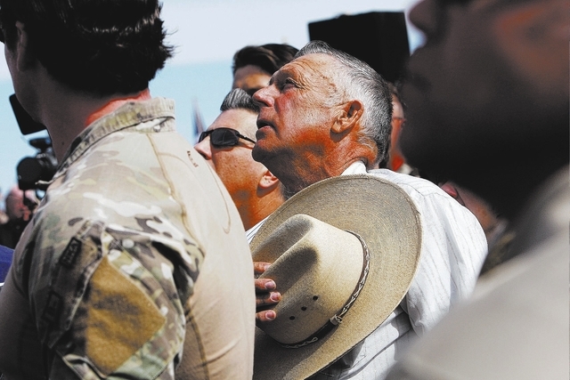 Rancher Cliven Bundy, middle, sings the National Anthem outside of Bunkerville while gathering with his supporters to challenge the BLM on April 12, 2014. (Jason Bean/Las Vegas Review-Journal)