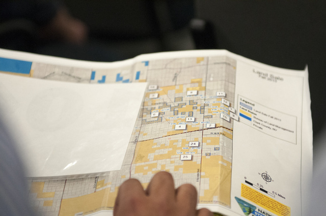 Manny Pattni, vice president at Lewis Operating Corp., looks at a map with available properties during a 28 parcel land sale auction at the Bureau of Land Management in Las Vegas Thursday, Jan. 16 ...