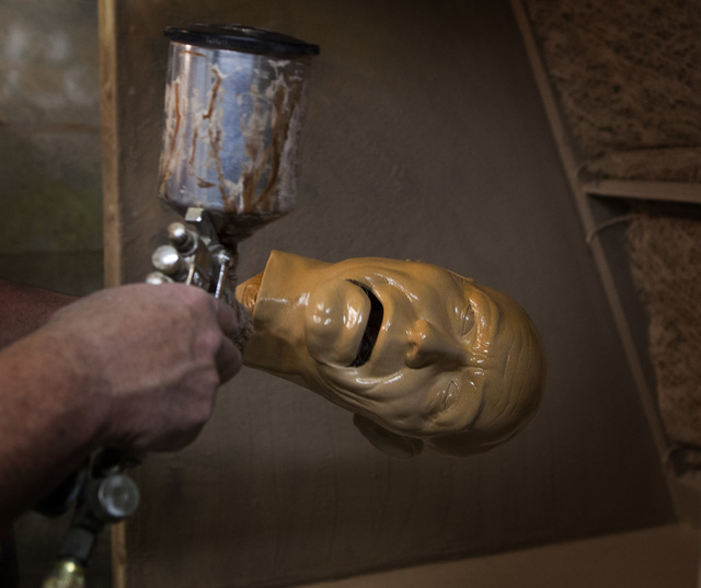 Tom Canterbury spray-paints an animatronic face. (Jeff Scheid/Las Vegas Review-Journal)