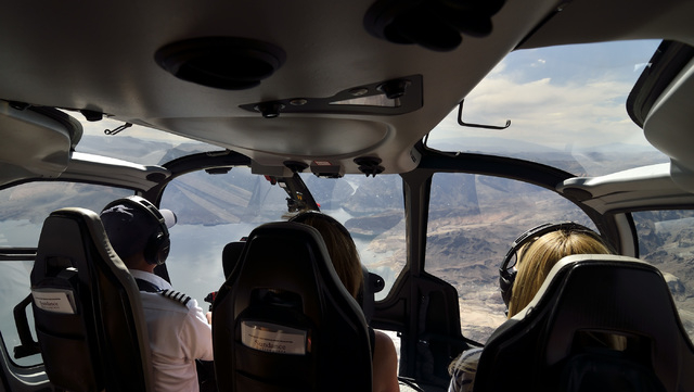 Pilot Chris Densmore, left, flies over Lake Mead with passengers Jules Bowen, center, and Zoe Williams after a Sundance Helicopters champagne lunch at the Grand Canyon on April 11. (Bill Hughes/La ...