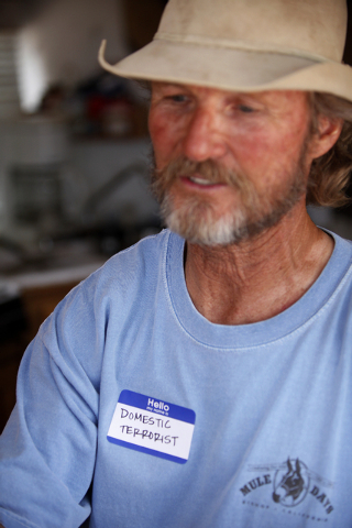 Thomas Firth wears a badge that says "domestic terrorist" in his RV at a protest camp near Bunkerville, Nev. Friday, April 18, 2014. (John Locher/Las Vegas Review-Journal)