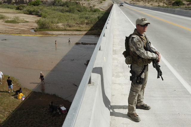 Justin Giles of Wasilla, Alaska stands on a bridge over the Virgin River during a rally in support of Cliven Bundy near Bunkerville, Nev. Friday, April 18, 2014. (John Locher/Las Vegas Review-Journal)