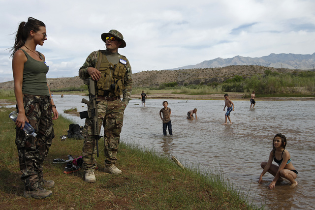 Jennifer Scalzo, left, and her husband Anthony Scalzo stand by the Virgin River during a rally in support of Cliven Bundy near Bunkerville, Nev. Friday, April 18, 2014. (John Locher/Las Vegas Revi ...