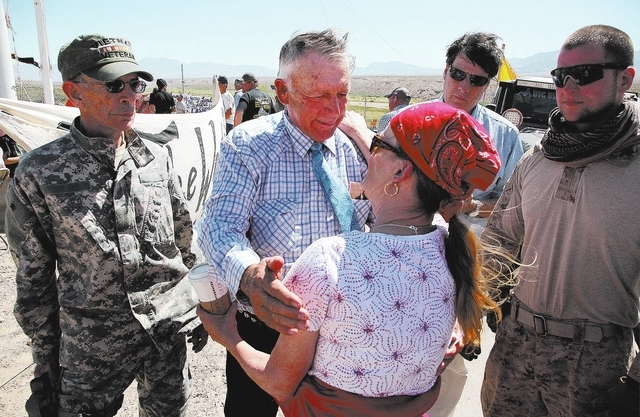 Rancher Cliven Bundy, center, greets Michelle Arnett, of Bullhead City, Ariz. near Bundy's ranch in Bunkerville on Sunday, April 13, 2014. Flanking Bundy are Jay Laduc, left, a member of the Minut ...