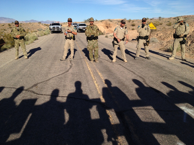 Bureau of Land Management law enforcement officers block the Overton Beach Road at the Lake Mead National Recreation Area near Overton, Nev. Thursday, April 10, 2014, as protestor's shadows are se ...