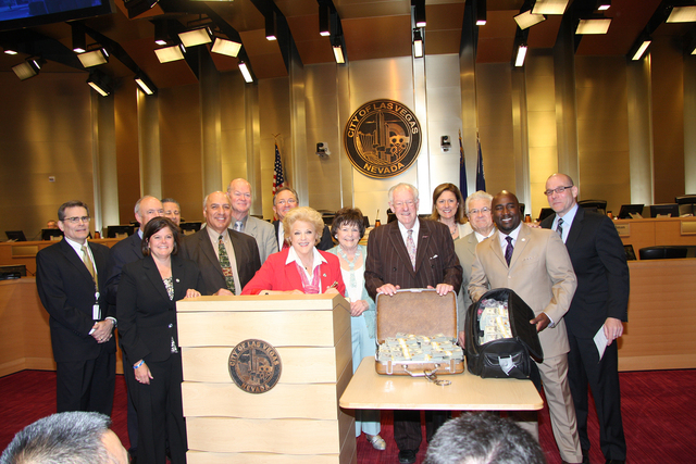 Former mayor Oscar Goodman rests his hands on a briefcase full of cash on Wednesday, surrounded by Las Vegas Mayor Carolyn Goodman, at the lectern, and Las Vegas City Council members. Mob Museum E ...