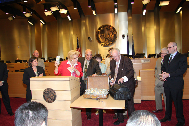 Las Vegas Mayor Carolyn Goodman holds up bundled cash that was delivered to City Hall by her husband, former mayor Oscar Goodman, and Mob Museum Executive Director Jonathan Ullman. The cash was an ...