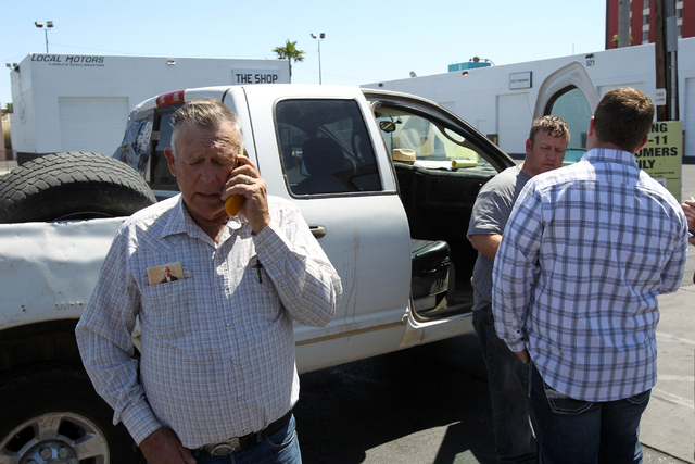 Embattled Bunkerville rancher Cliven Bundy, left, talks on the phone while his son Dave Bundy, second from left, and son-in-law Josh Logue to a reporter on the corner of North Las Vegas Boulevard  ...