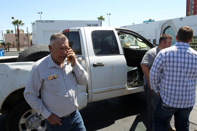 Embattled Bunkerville rancher Cliven Bundy, left, talks on the phone while his son Dave Bundy, second from left, and son-in-law Josh Logue to a reporter on the corner of North Las Vegas Boulevard  ...