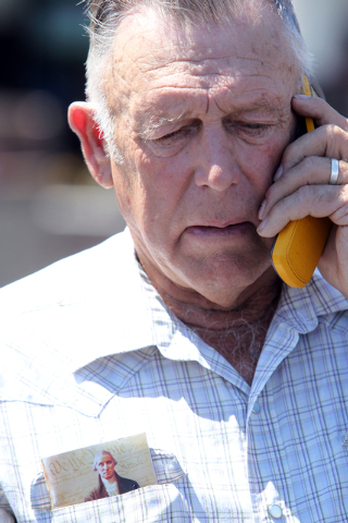Embattled Bunkerville rancher Cliven Bundy talks on the phone on the corner of North Las Vegas Boulevard and East Stewart Avenue after picking up his son Dave Bundy who was released from federal c ...