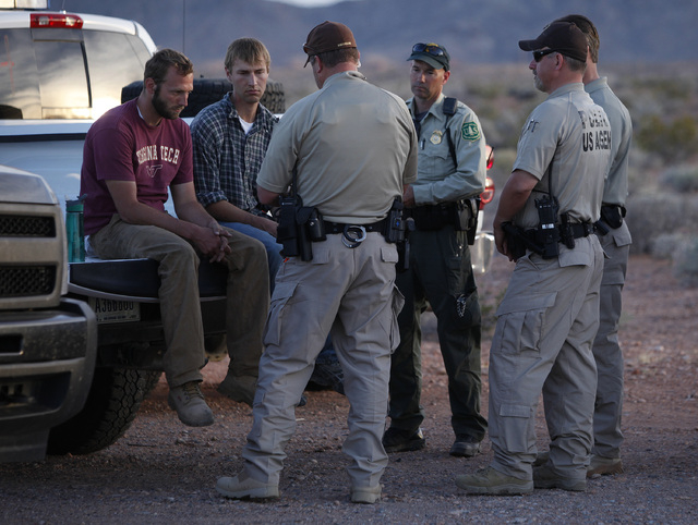 Tyler Shillig, left, and Spencer Shilling sit on a truck before they are released by federal law enforcement officers at the Lake Mead National Recreation Area near Overton, Nev. Thursday, April 1 ...