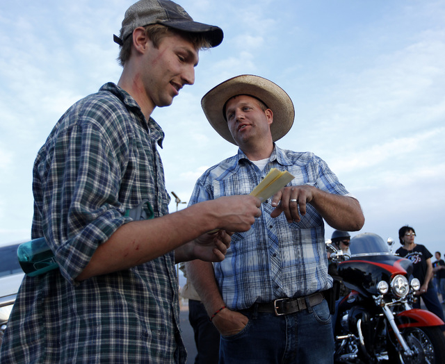 Ammon Bundy, right, talks with Spencer Shillig at the Lake Mead National Recreation Area near Overton, Nev. Thursday, April 10, 2014. Shillig and his brother were detained while protesting the rou ...