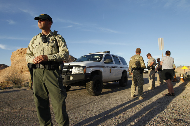 Federal law enforcement officers guard a convoy of cattle at the Lake Mead National Recreation Area near Overton, Nev. Thursday, April 10, 2014. Two people were detained while protesting the round ...