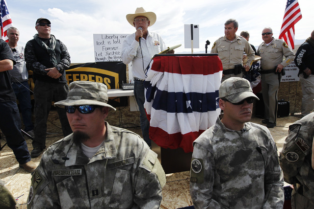 Rancher Cliven Bundy, middle, addresses his supporters along side Clark County Sheriff Doug Gillespie, right, on April 12, 2014. Bundy informed the public that the BLM has agreed to cease the roun ...