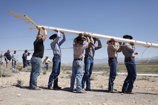 People help erect a pole to hang a banner during a rally in support of Cliven Bundy near Bunkerville Nev. Monday, April 7, 2014, 2014. The Bureau of Land Management has begun to round up what they ...