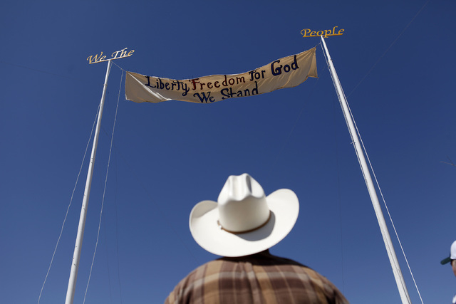 A man looks at a banner during a rally in support of Cliven Bundy near Bunkerville Nev. Monday, April 7, 2014, 2014. The Bureau of Land Management has begun to round up what they call "trespa ...