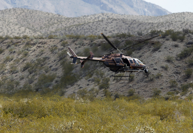 A helicopter takes off from a staging area of Bureau of Land Management vehicles and other government vehicles off of Riverside Road near Bunkerville, Nev. Saturday, April 5, 2014. The Bureau of L ...