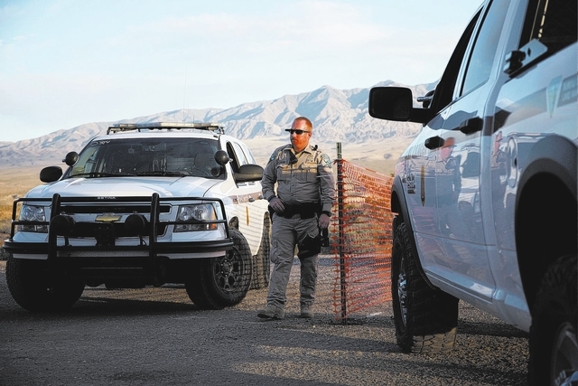 A Bureau of Land Management ranger stands guard at the entrance of a staging near Mesquite on Saturday, April 5, 2014. The Bureau of Land Management has begun to round up what they call "trespass  ...