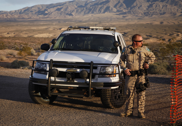 A Bureau of Land Management ranger stands guard at the entrance of a staging area near Mesquite on Saturday, April 5, 2014. The Bureau of Land Management has begun to round up what they call "tres ...