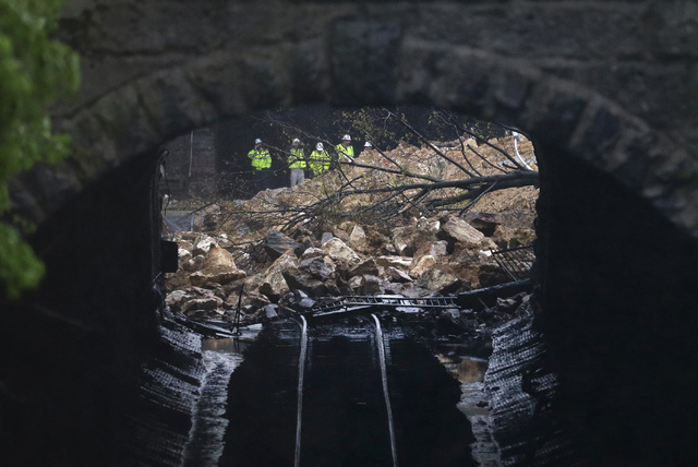 Emergency officials are seen through a CSX railroad tunnel near debris that fell onto tracks in the Charles Village neighborhood of Baltimore, Wednesday, April 30, 2014, as heavy rain moves throug ...