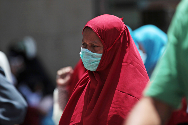 In this photo taken Tuesday, May 13, 2014, a Muslim pilgrim wears a surgical mask to prevent infection from respiratory virus known as the Middle East respiratory syndrome (MERS) in the holy city  ...