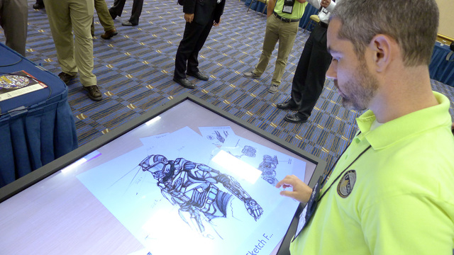 Michael Fieldson , the civilian project manager for the Tactical Assault Light Operator Suit at McDill Air Force Base, looks at sketches of the body armor exoskeleton during the Special Operations ...