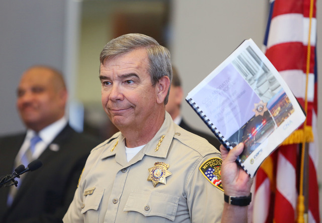 Clark County Sheriff Doug Gillespie holds up a report during a news conference at the Lloyd D. George U.S. Courthouse Wednesday, May 21, 2014, in Las Vegas. The Office of Community Oriented Polici ...