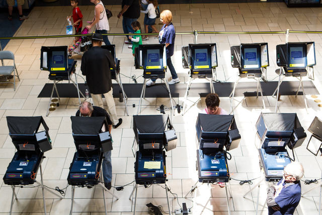 Las Vegas residents, clockwise from center right, Pat Lawrence, Aubrey Roberson, and Anders Denson cast their ballots on the first day of early voting at the Meadows Mall in Las Vegas on Saturday, ...