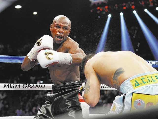 Floyd Mayweather Jr. misses landing a punch against Marcos Maidana during their welterweight title bout at the MGM Grand in Las Vegas Saturday, May 3, 2014. Mayweather was bloodied above his left  ...