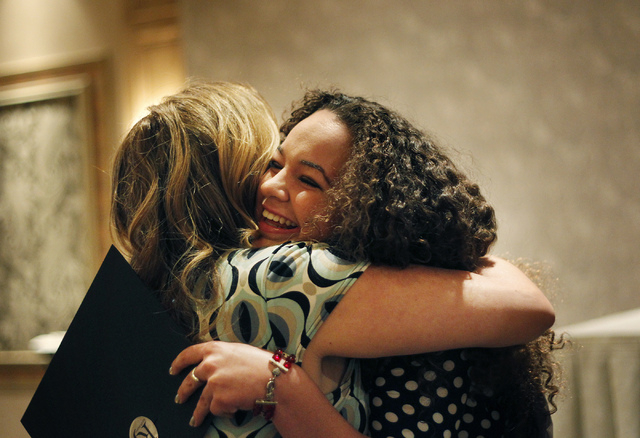 Las Vegas Academy senior Shannon Sneade, right, hugs Rjeneration director and mentor Lindsey Collins after receiving a scholarship award during the High School Journalism Awards lunch at the Sunco ...