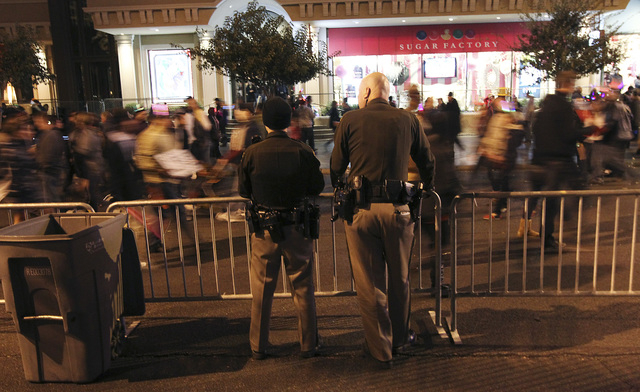 Metro Officers Nate Jones, left, and Paul Hunter watch as people go by on the Las Vegas Strip during the New Year's Eve celebration on the Las Vegas Strip on Dec. 31, 2012. (Jason Bean/Las Vegas R ...