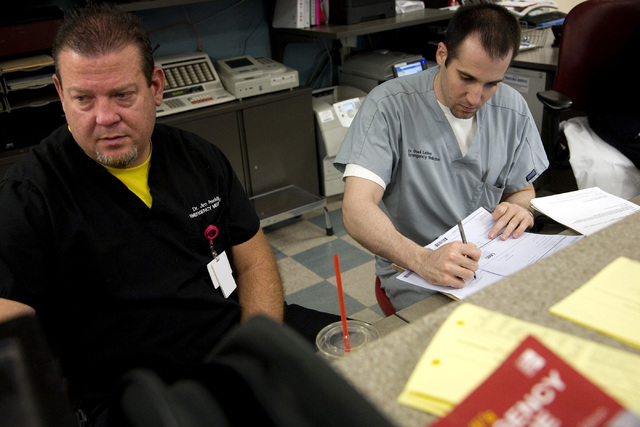 Dr. Jim Preddy, left, and Dr. Shadi Lahham, a third-year emergency medicine resident, do paperwork at University Medical Center Trauma Center in Las Vegas on Saturday, May 10, 2014. (Jeferson Appl ...