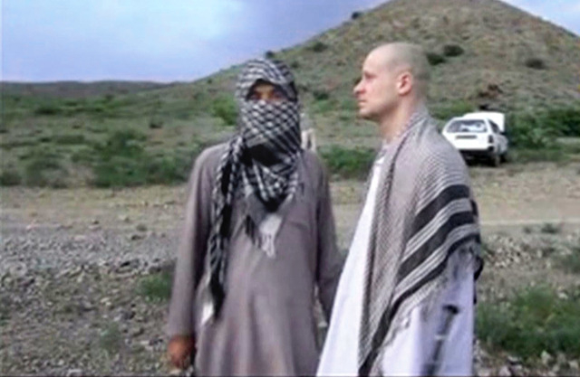 In this image taken from video obtained from Voice Of Jihad Website, which has been authenticated based on its contents and other AP reporting, Sgt. Bowe Bergdahl, right, stands with a Taliban fig ...