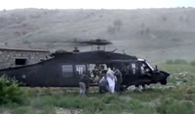 In this image taken from video obtained from Voice Of Jihad Website, men in civilian clothing lead Sgt. Bowe Bergdahl, in white, toward a helicopter in eastern Afghanistan. The Taliban on Wednesda ...
