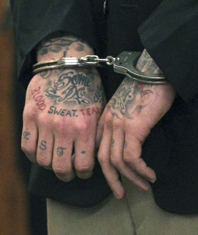 Former New England Patriots NFL football player Aaron Hernandez's tattooed hands are secured with handcuffs as he arrives for his court appearance at Superior Court in Fall River, Mass. Hernandez  ...