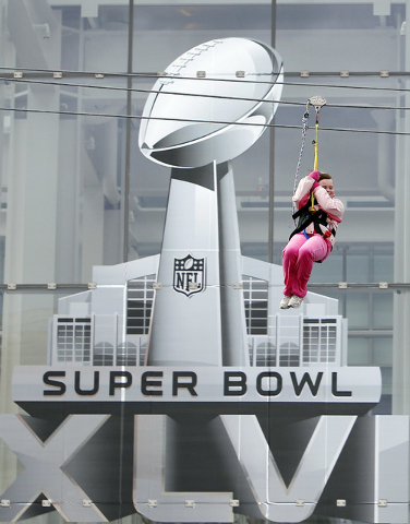 In this Jan. 29, 2012 file photo, a fan rides a zip line during the NFL Experience for Super Bowl XLVI in Indianapolis. The 50th edition of the game will be played in February 2016 in Santa Clara, ...