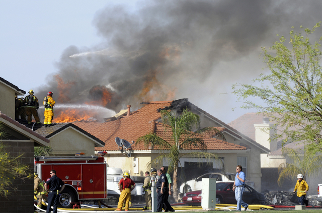 This photo shows the site of a military jet that crashed on a residential street in the desert community of Imperial, Calif., setting two homes on fire Wednesday, June 4, 2014. Lance Cpl. Christop ...