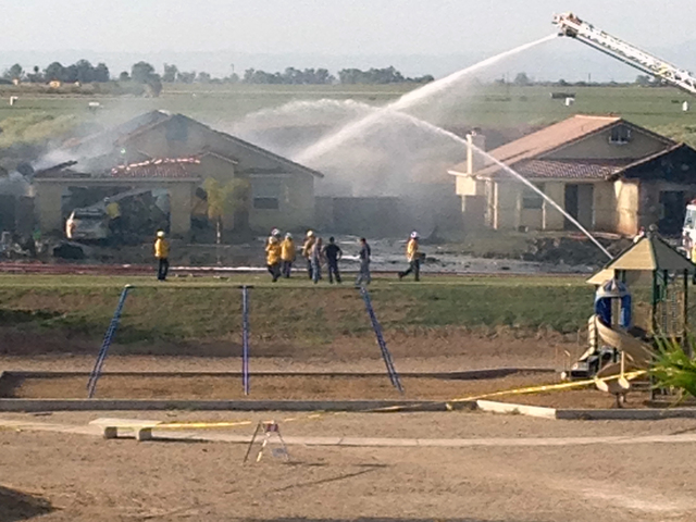 This photo provided by Isaac Ramos shows firefighters putting out a fire caused when a military jet crashed in residential neighborhood in Imperial, Calif., Wednesday, June 4, 2014. Witnesses say  ...
