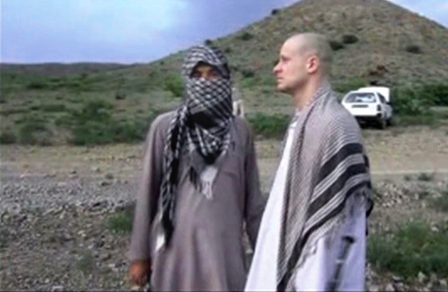 In this file image taken from video obtained from Voice Of Jihad Website, which has been authenticated based on its contents and other AP reporting, Sgt. Bowe Bergdahl, right, stands with a Taliba ...