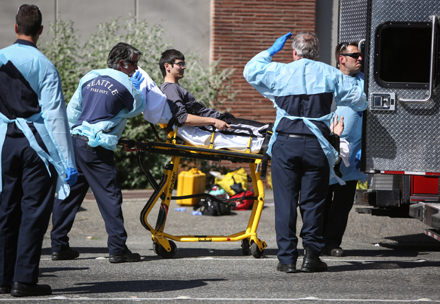 Jon Meis is taken from the scene by medics after a shooting at Seattle Pacific University on Thursday, June 5, 2014 in Seattle. A 19-year-old man was fatally shot and two other young people were w ...