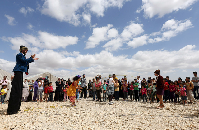 In this June 6, 2014 photo, members of "Clowns Without Borders" perform for children at a Syrian refugee camp in the eastern town of Chtoura, in Bekaa valley, Lebanon. The children are a ...