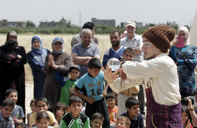 In this June 6, 2014 photo, Chilean clown Claudio, a member of "Clowns Without Borders" performs for children at a Syrian refugee camp in the eastern town of Chtoura, in Bekaa valley, Le ...
